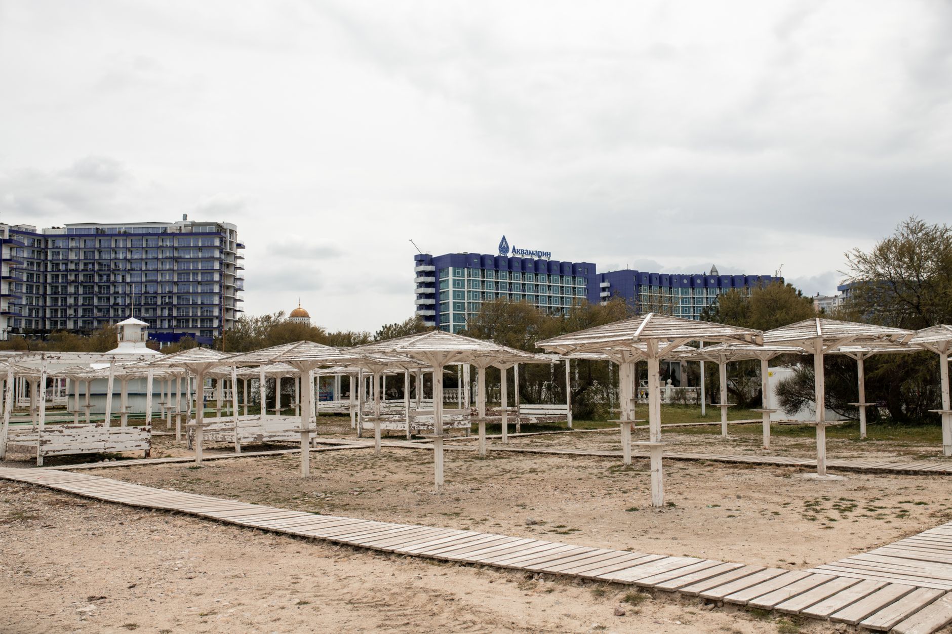 Deserted seaside resort with modern high-rise hotels in Sevastopol, under overcast skies.