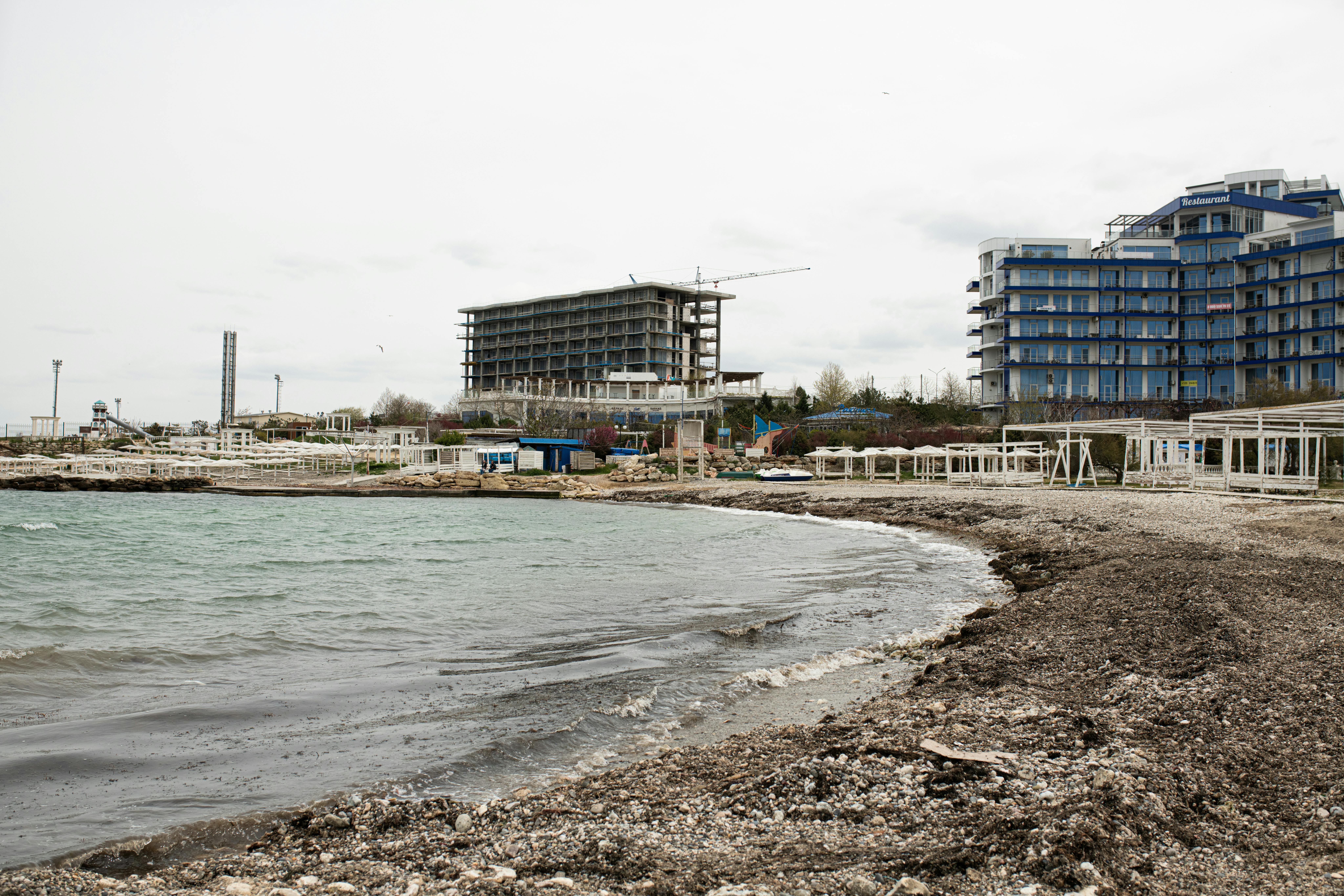 Beachfront construction site and resort buildings along the Sevastopol coastline.