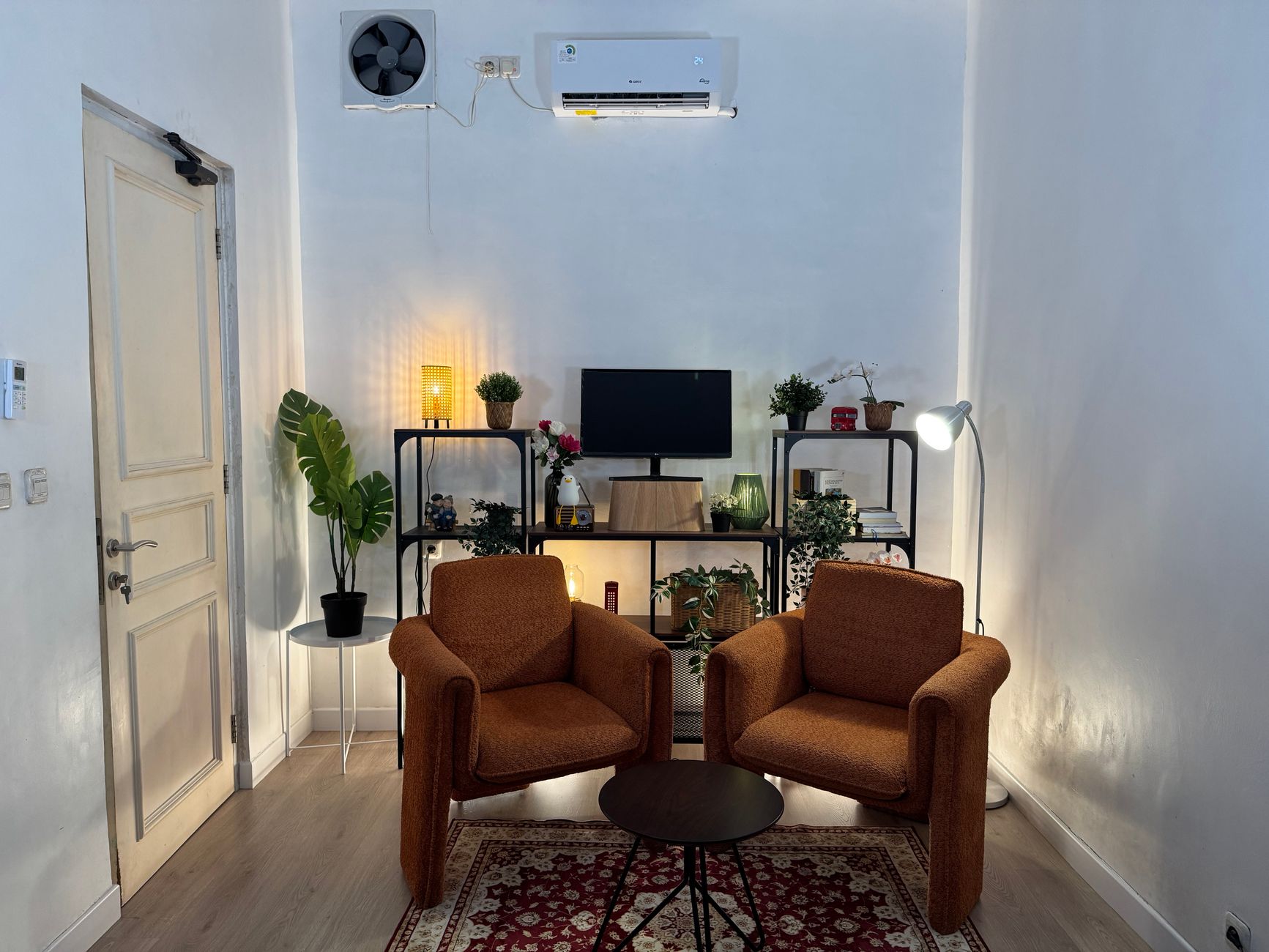 luxury studio apartment inspiration for small spaces Inviting home office with cozy armchairs, plants, and well-organized shelves.