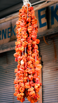 Vibrant strings of dried red peppers on display at a local market. - Fotografer Sidoarjo