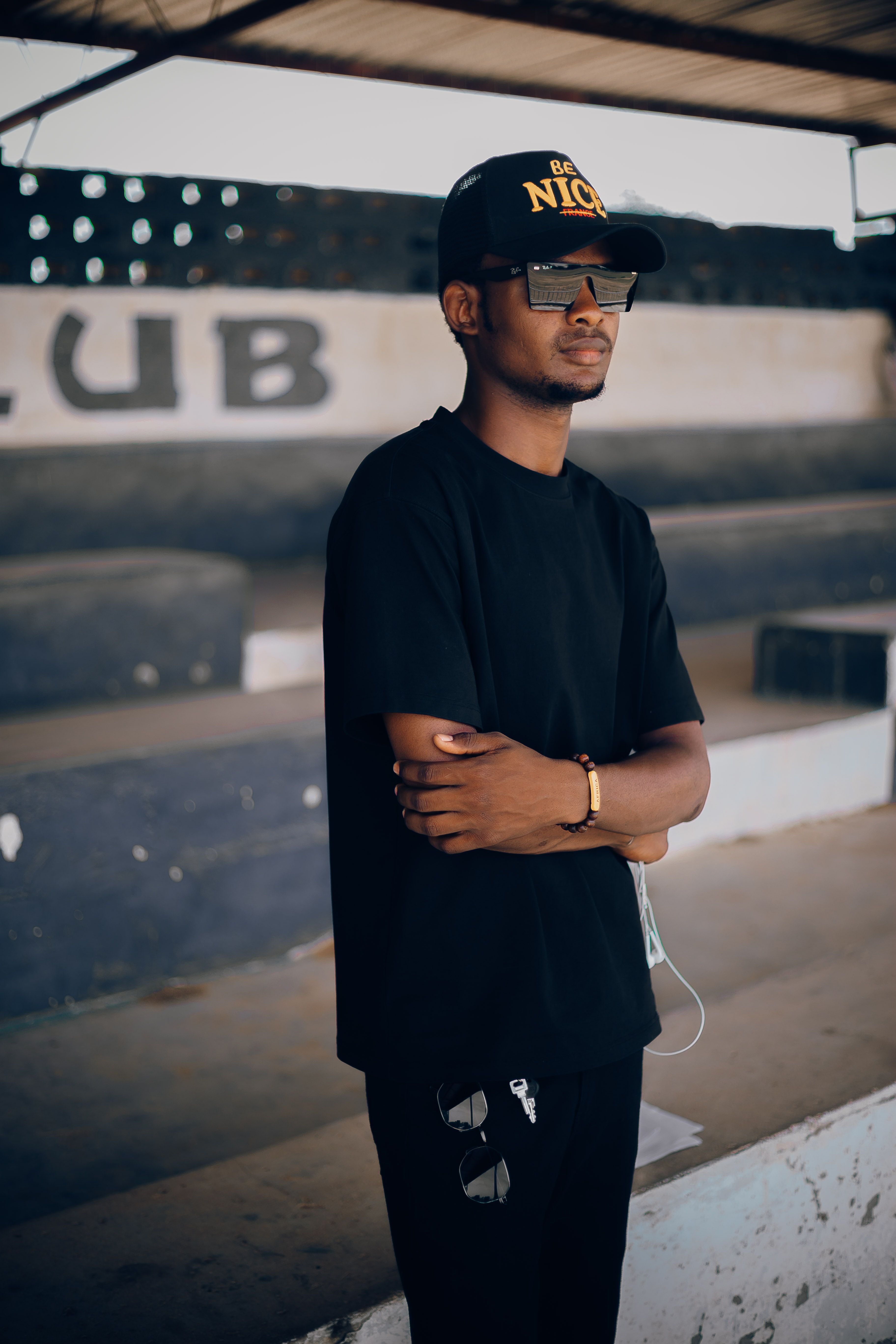Young man in casual attire standing confidently in an urban Nigerian setting.