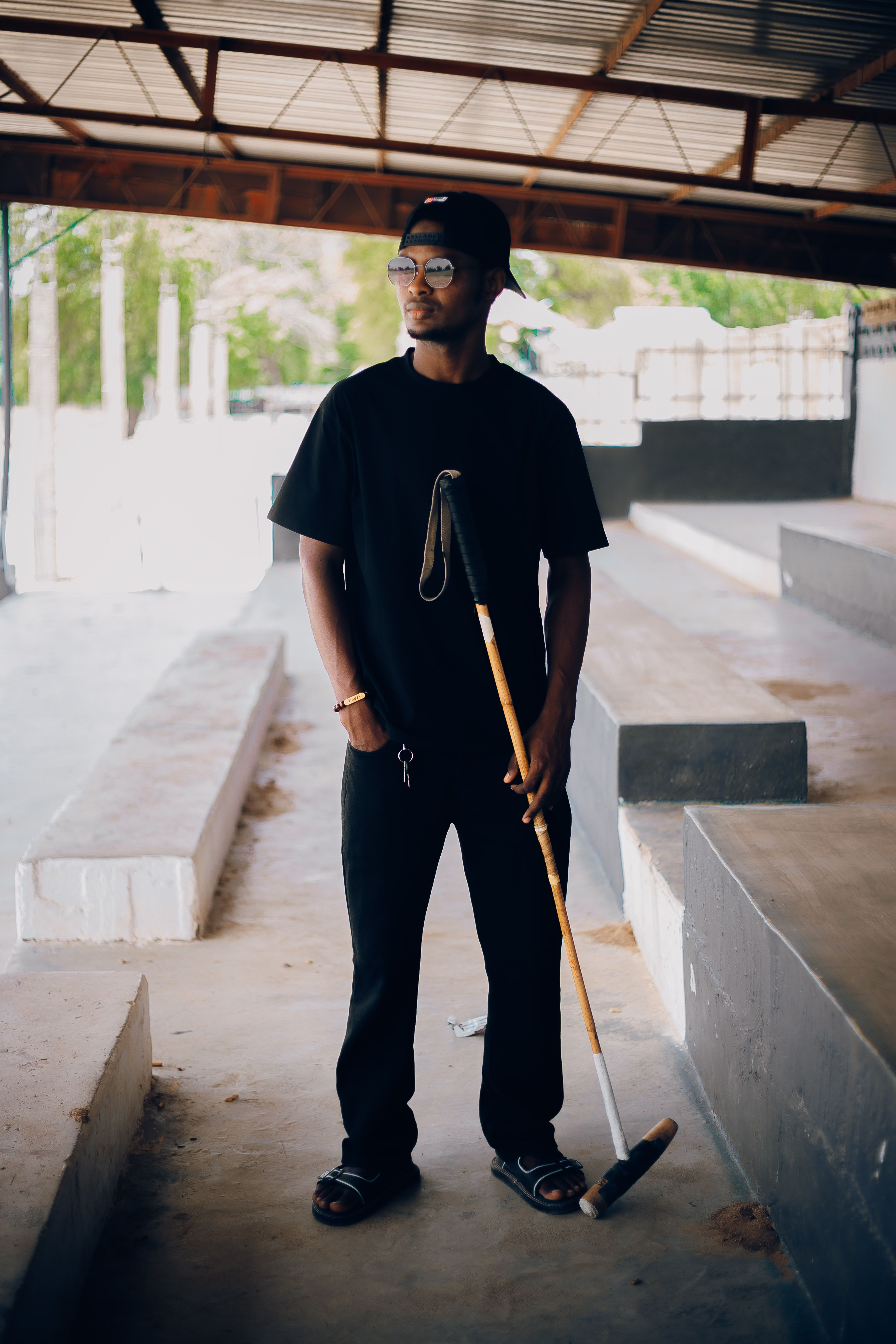 Stylish young man holding a polo mallet outdoors in Nigeria.