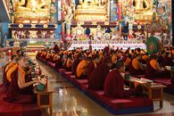 Monks gathered in prayer and meditation at a temple in Madikeri, Karnataka, India.