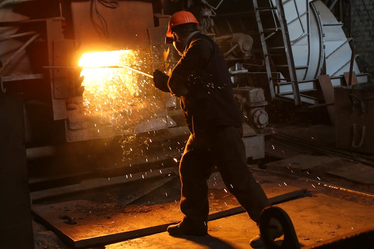 Man In Helmet Working With Steel In Furnace