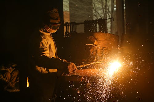 Male employee working with welding machine