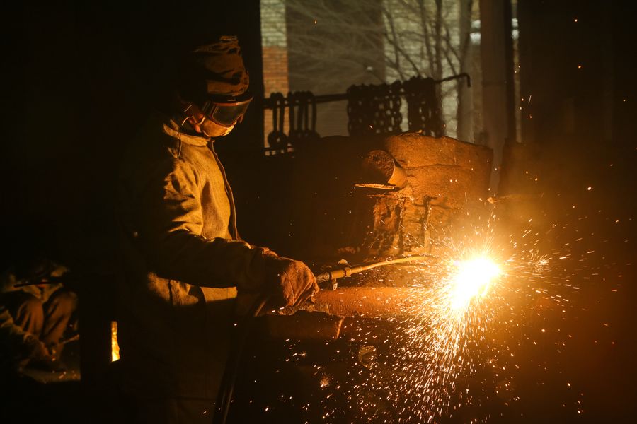 Night welding with a shower of orange sparks