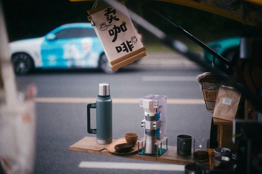 Cozy street coffee setup in Chengdu with thermos and cups on display, perfect for urban caffeine lovers.