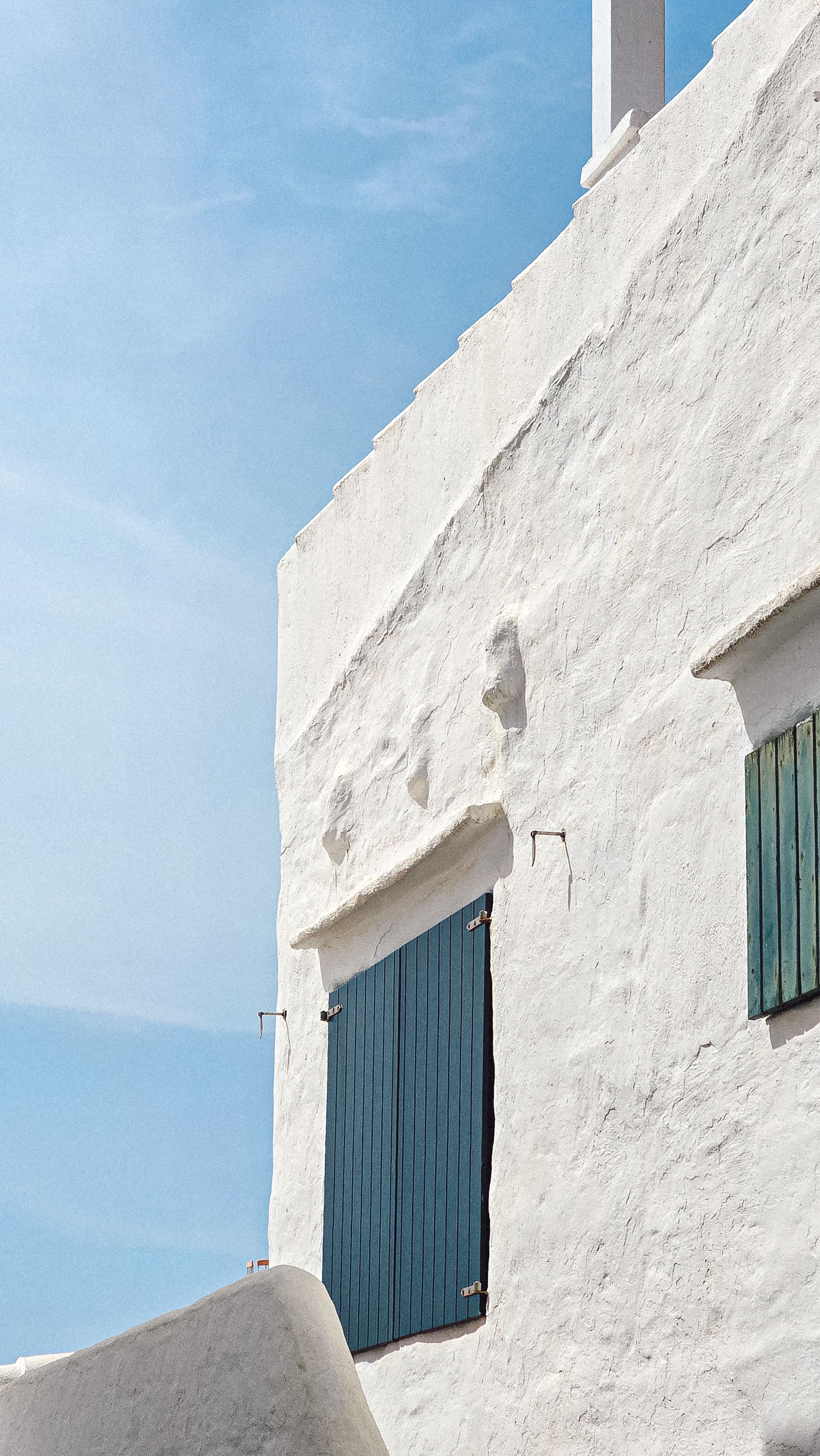 Whitewashed architecture in Binibeca, Spain, under a clear blue sky.