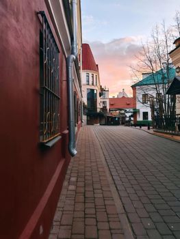 Peaceful street in Minsk, Belarus with colorful architecture and sunset sky.