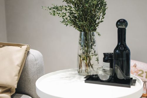 Free Chic interior showcasing stylish decor with a vase and glass bottle on a round table. Stock Photo