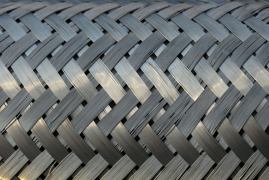 Detailed view of a metallic mesh with interwoven strands, showcasing industrial design and texture.