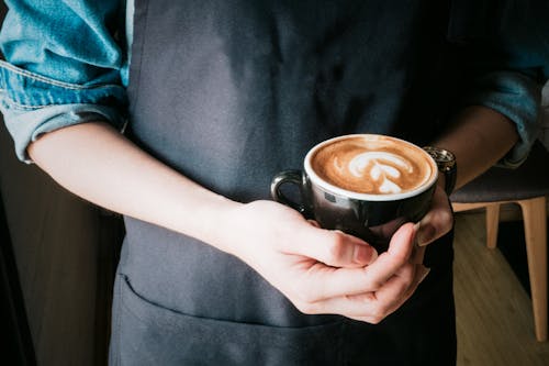 Femme Tenant Une Tasse De Cappuccino