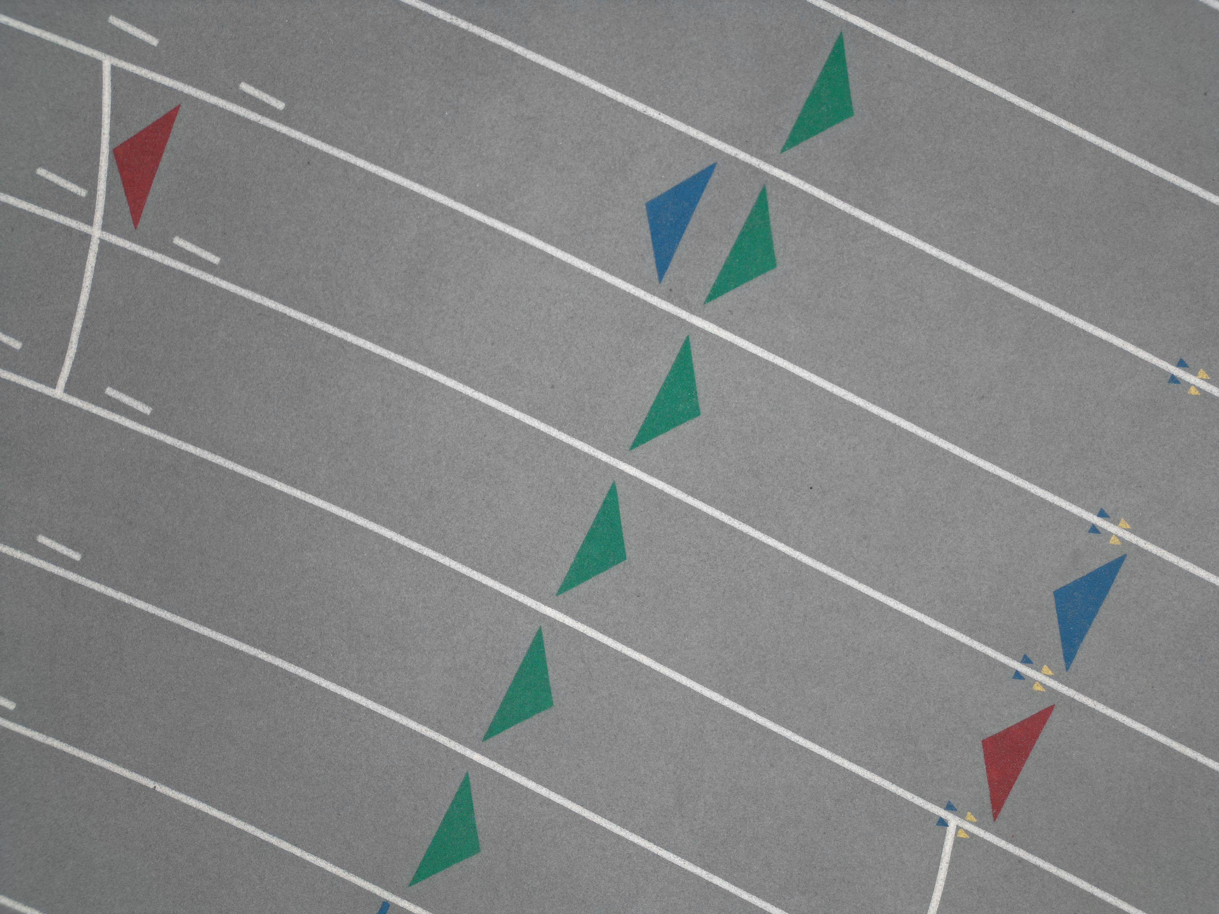 Aerial shot highlighting the geometric design of a multi-colored athletic track.