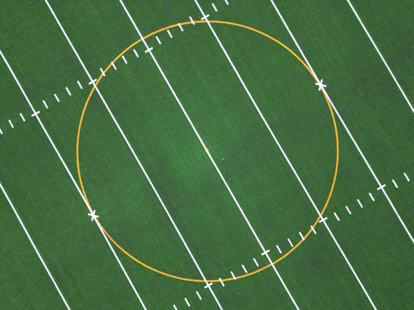 High-angle drone shot of a perfectly symmetrical soccer field with vibrant lines.