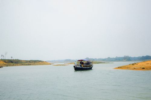 Free Peaceful scenery of a traditional boat on a serene river in Bangladesh, perfect for travel and nature themes. Stock Photo
