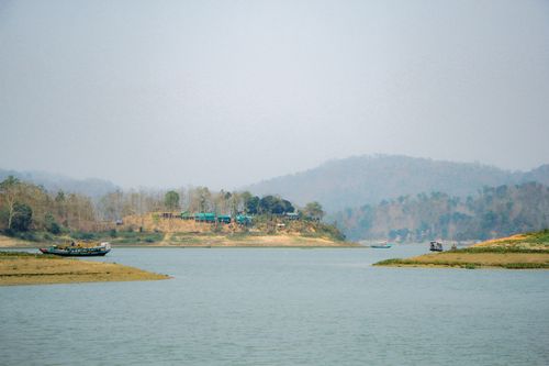 Free Peaceful scene of boats on a serene lake with distant hills in Bangladesh. Stock Photo