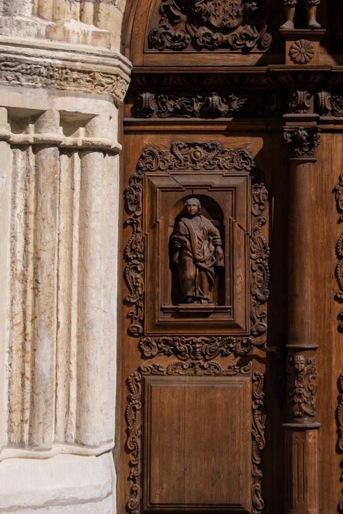Free Detailed carved wooden door with a sculpture in Tallinn, Estonia. Architectural beauty and craftsmanship. Stock Photo