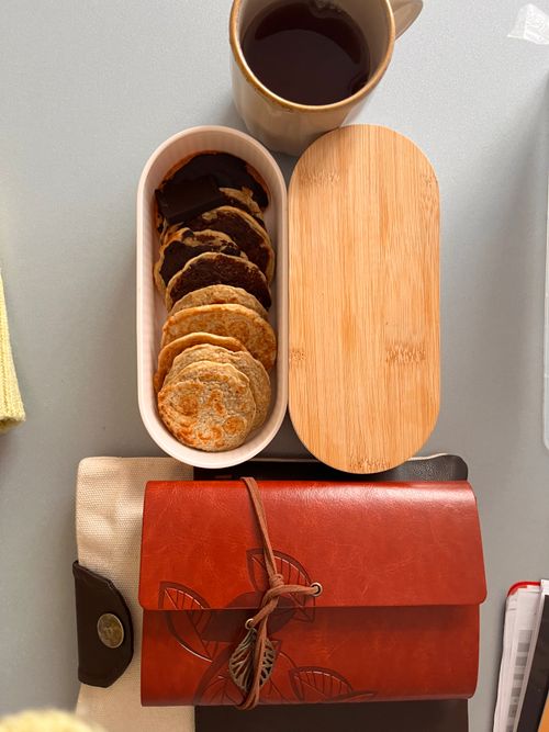 Free Aesthetic flat lay of assorted cookies, a cup of tea, and a stylish leather journal. Stock Photo