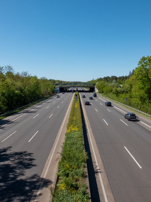 Free Clear view of highway traffic surrounded by greenery and blue sky. Stock Photo