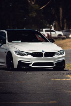 White sport car parked on a sunny road in Dolores, Argentina with blurred background.