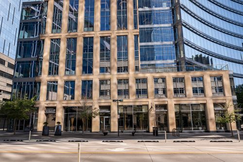 Free Contemporary urban architecture featuring a sleek office building with glass facades and reflections. Stock Photo