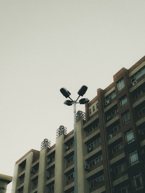 Free A modern urban building facade with streetlight against a serene evening sky. Stock Photo