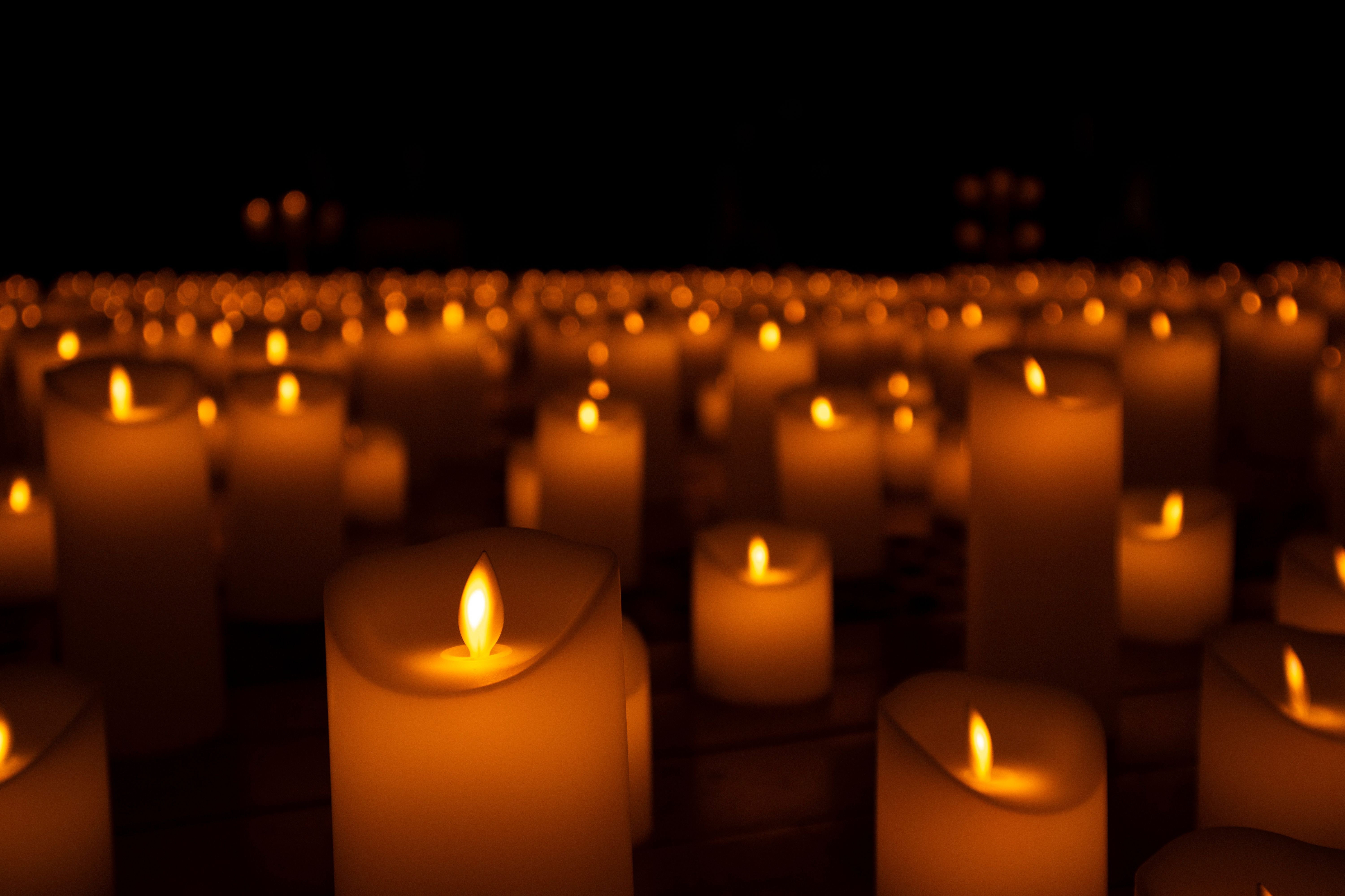 Soft focus on glowing candles creating a warm and tranquil ambiance in the dark.