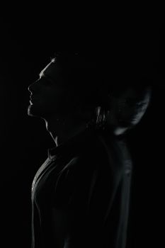 Artistic silhouette of a man in low light, evoking introspection and mystery.