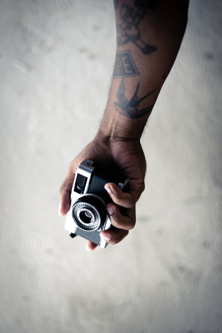 Person Holding Black And Silver Camera 