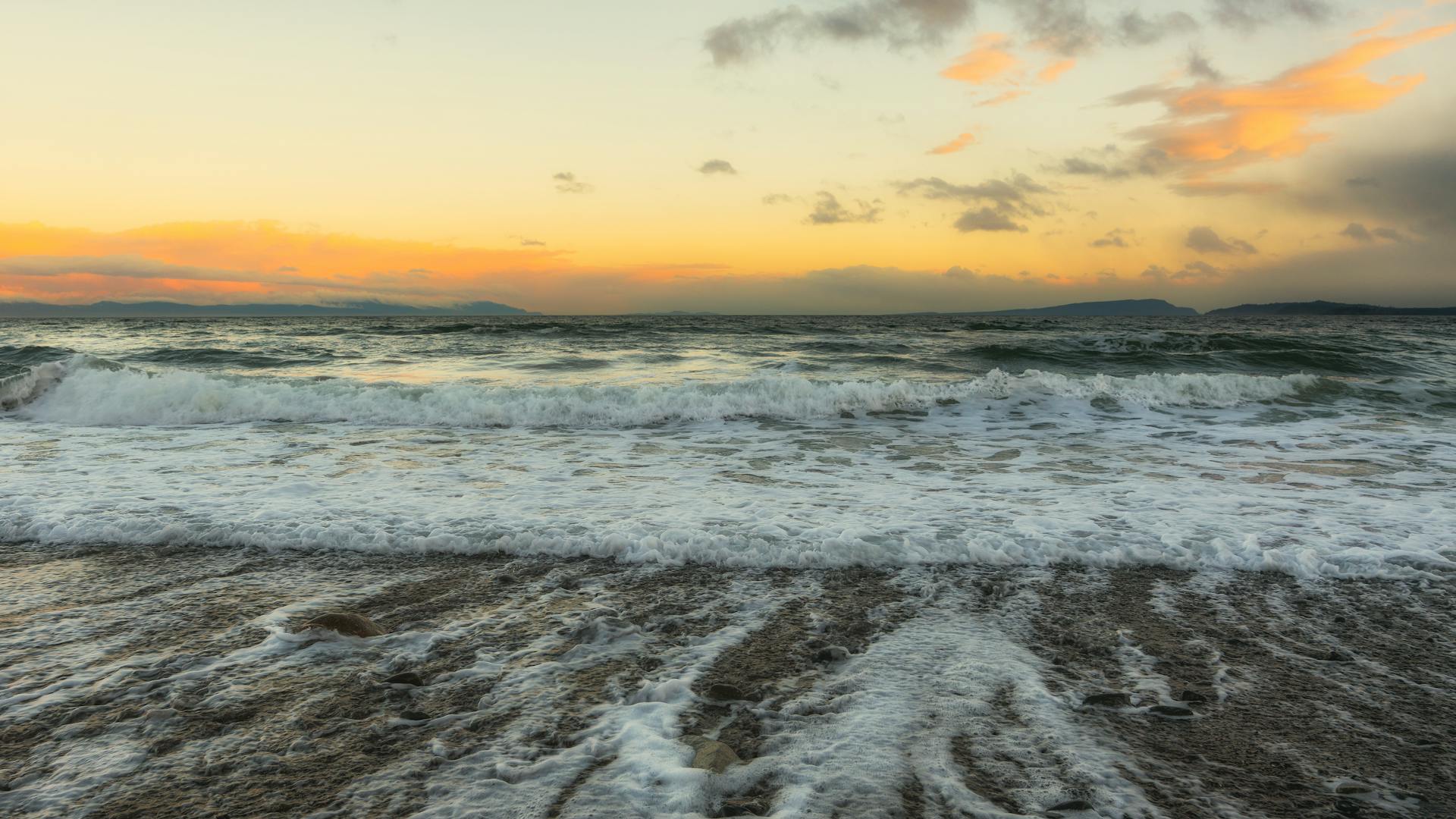 Peaceful seaside sunset with gentle waves at Comox, British Columbia coast.