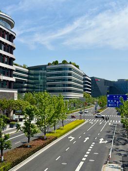 Contemporary urban street view in Shanghai featuring modern office buildings and clear blue skies.