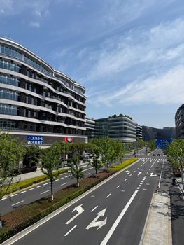 A wide road in Shanghai's business district with modern architecture and clear blue sky.