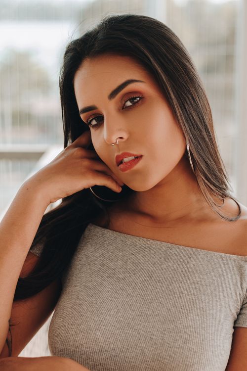Free Close-up portrait of a fashionable woman with a nose piercing and red lips, showcasing her elegant style. Stock Photo