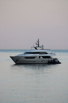 A luxurious yacht cruising at sunrise near the Italian coast of Portofino, Liguria.