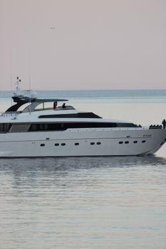 Elegant yacht sailing in Portofino's serene coastline at sunset. Perfect for luxury travel and coastal exploration.