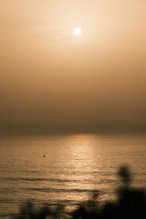 Free A tranquil sunset reflecting on calm ocean waters, creating a warm and peaceful ambiance. Stock Photo