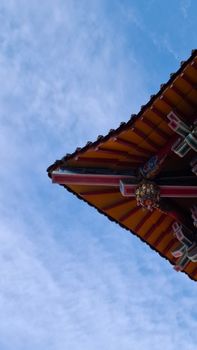 Captivating view of a traditional Asian temple roof with vibrant colors set against a clear blue sky.