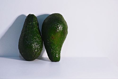 Free Two fresh avocados on a clean white background, highlighting healthy nutrition. Stock Photo