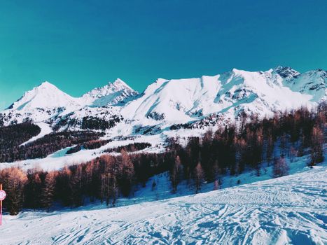 Breathtaking view of snowcapped mountains under a clear blue sky, perfect for winter travel.