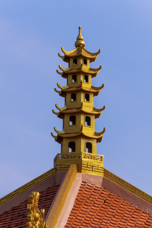 Free Vertical shot of a traditional pagoda tower against a clear blue sky, showcasing Asian architecture. Stock Photo