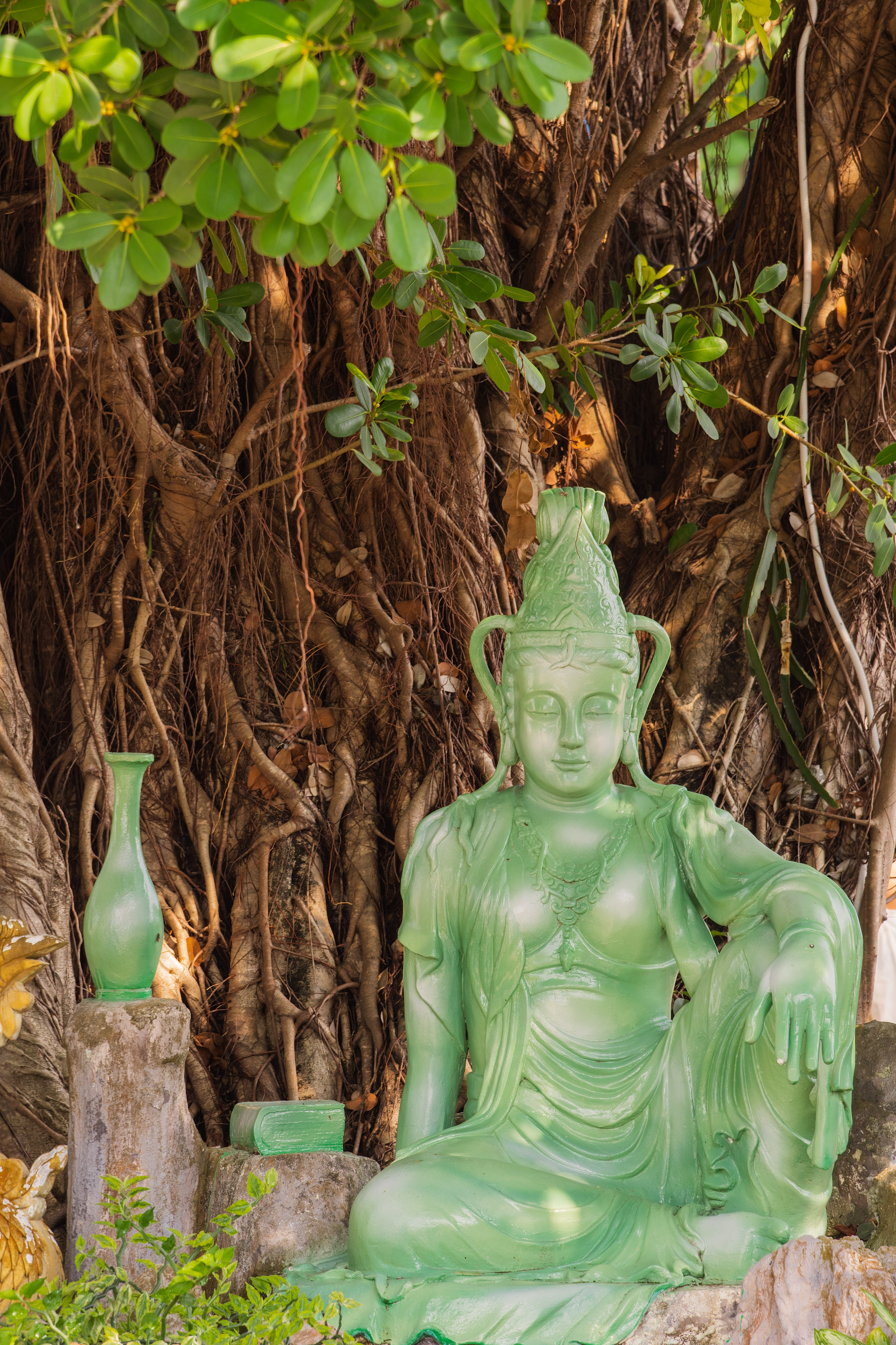 Serene Green Buddha Statue Amidst Lush Foliage · Free Stock Photo