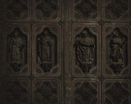 Intricate bronze door featuring detailed sculptures of historical figures, showcasing classic artistry.