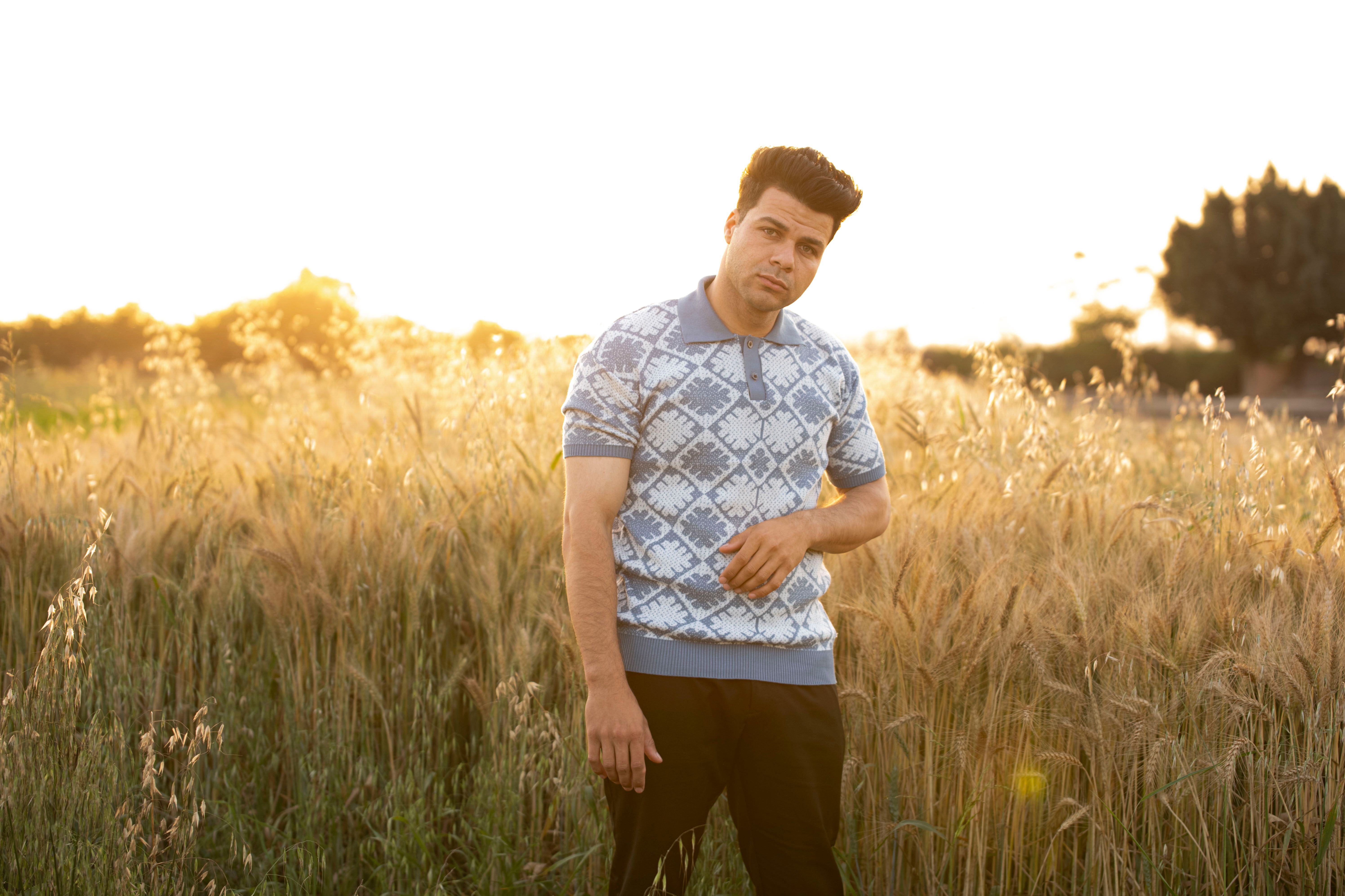 Man in Wheat Field at Sunset Capturing Tranquility · Free Stock Photo
