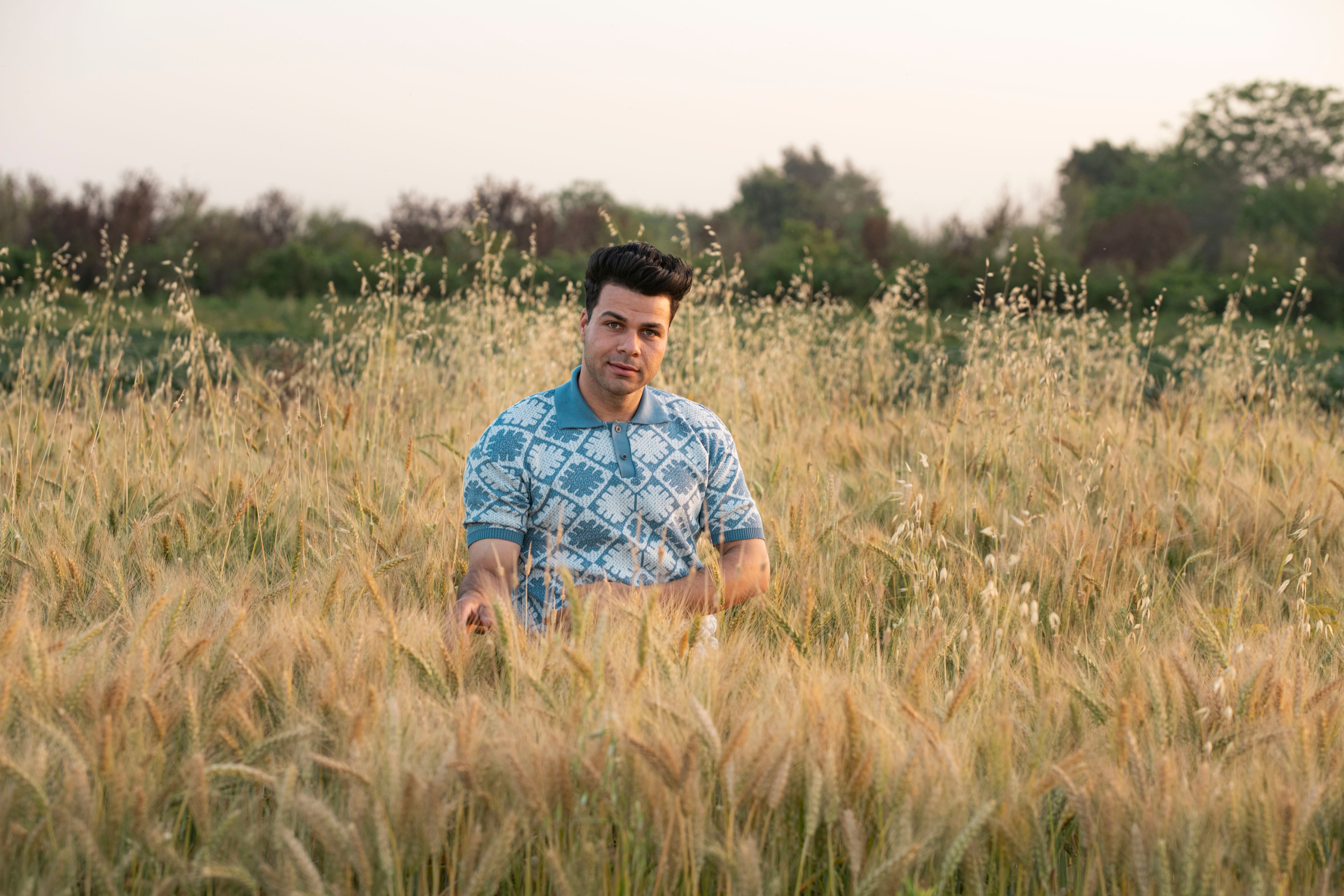 Man Standing in a Wheat Field at Dusk · Free Stock Photo