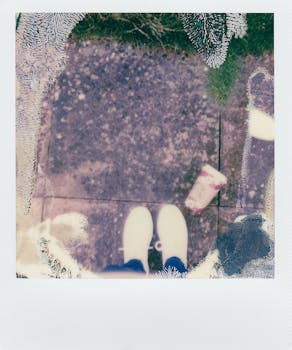 褪色的即时电影照片显示，户外人行道上有一双白色运动鞋和垃圾