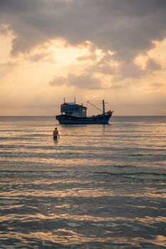 A tranquil scene of a fishing boat at sunset in Đông Ninh Hòa, Vietnam.