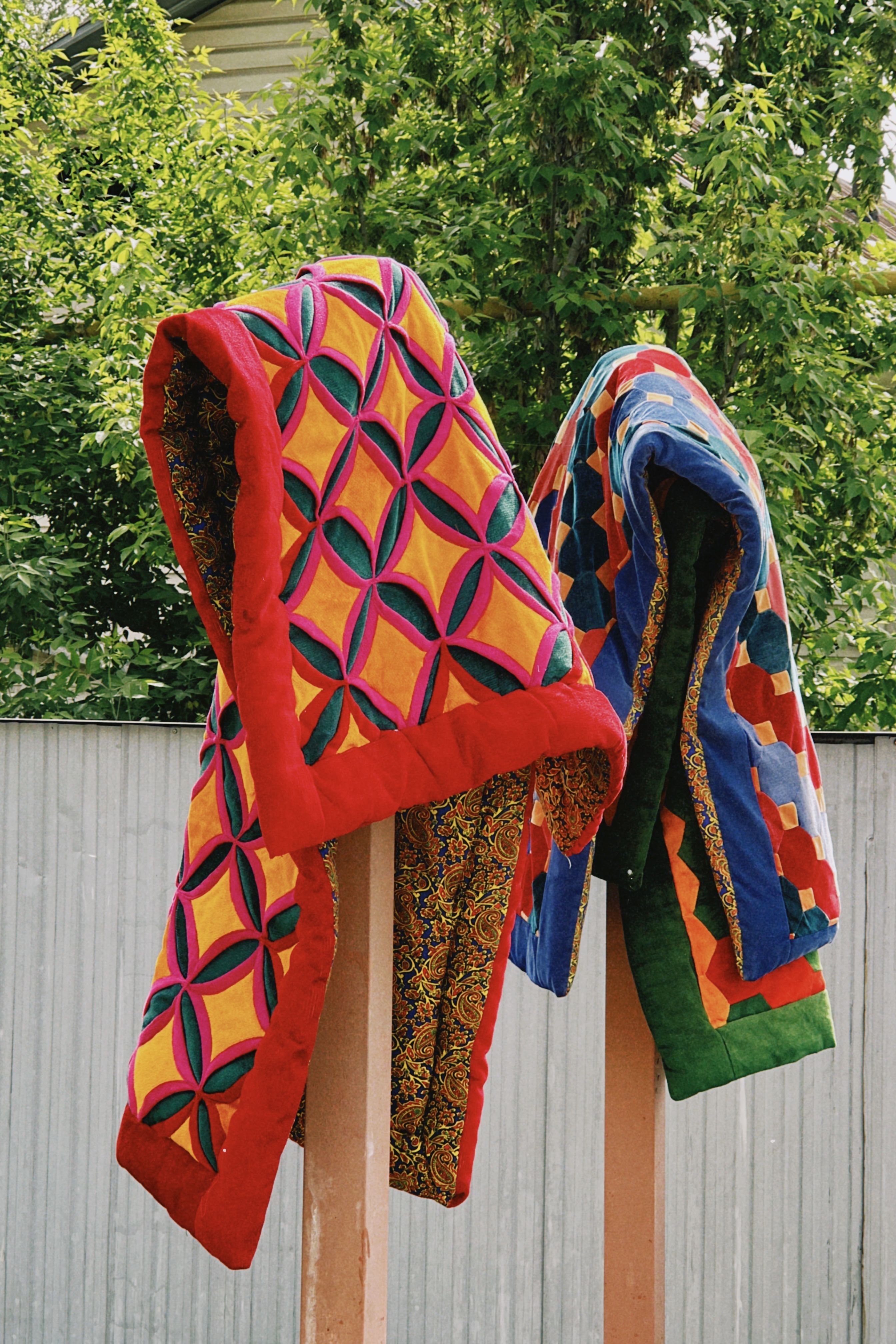 Colorful quilts with geometric patterns hanging outdoors in Talgar, Kazakhstan.