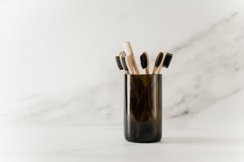 Free Black Plastic Cup With Wooden Toothbrushes Stock Photo