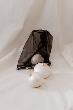 Elegant still life featuring onions in a black mesh bag, depicting eco-friendly, zero-waste lifestyle.