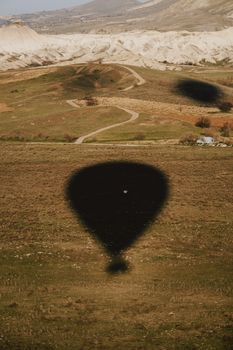 Captivating view of hot air balloon shadows cast on a scenic landscape.